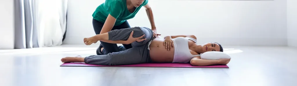 Woman having treatment for back pain during pregnancy